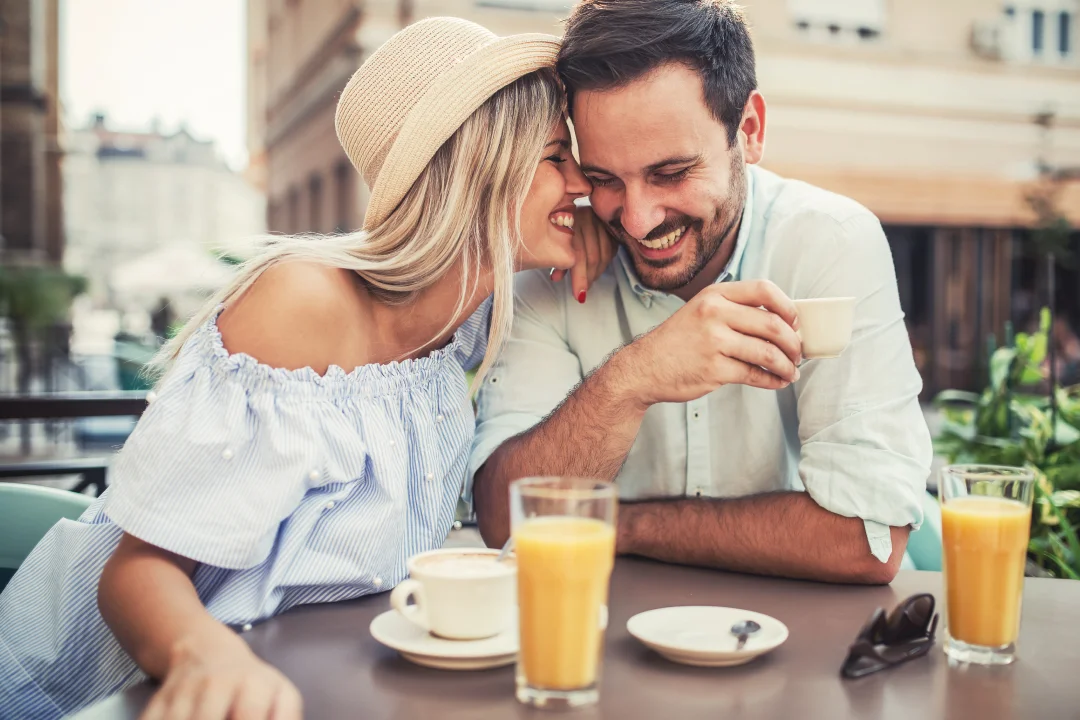 adult couple having brunch outside on a patio sitting closely and smiling