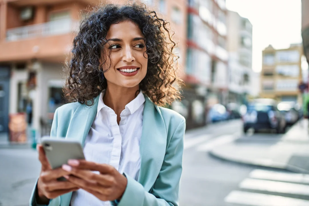 adult female professional holding smartphone and smiling confidently